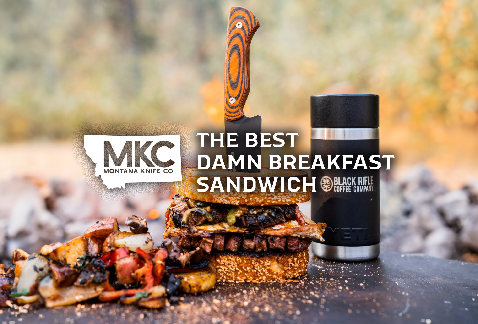 A hearty steak-and-egg breakfast sandwich sits outdoors on a clean slab, stabbed through with an MKC knife. 