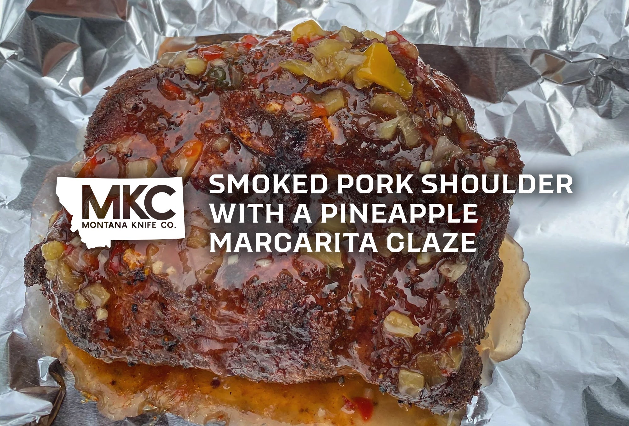 Smoked pork shoulder topped with pineapple margarita glaze on foil.