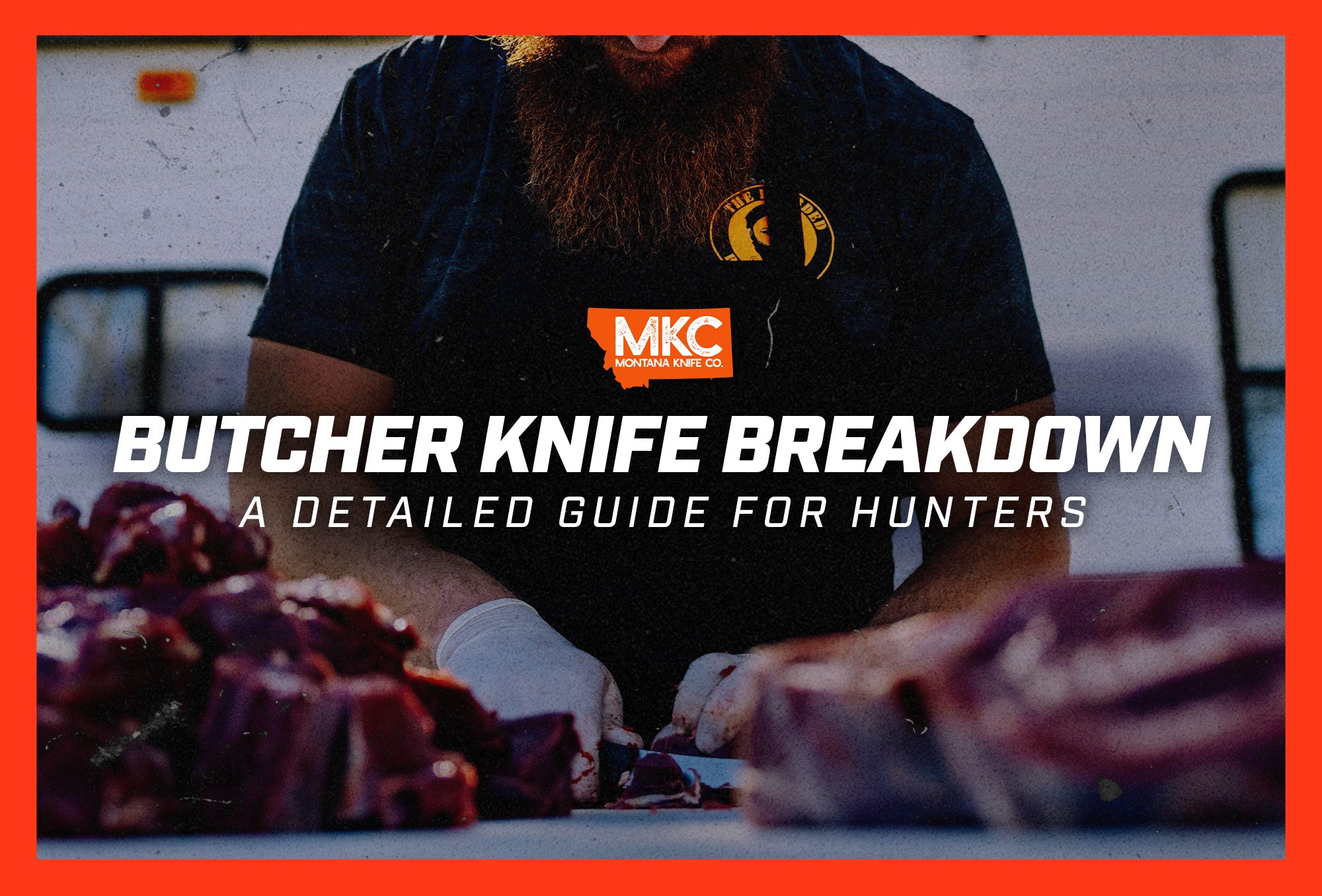 A bearded man wearing gloves and a black apron uses a butcher knife to slice through large cuts of meat on a counter.