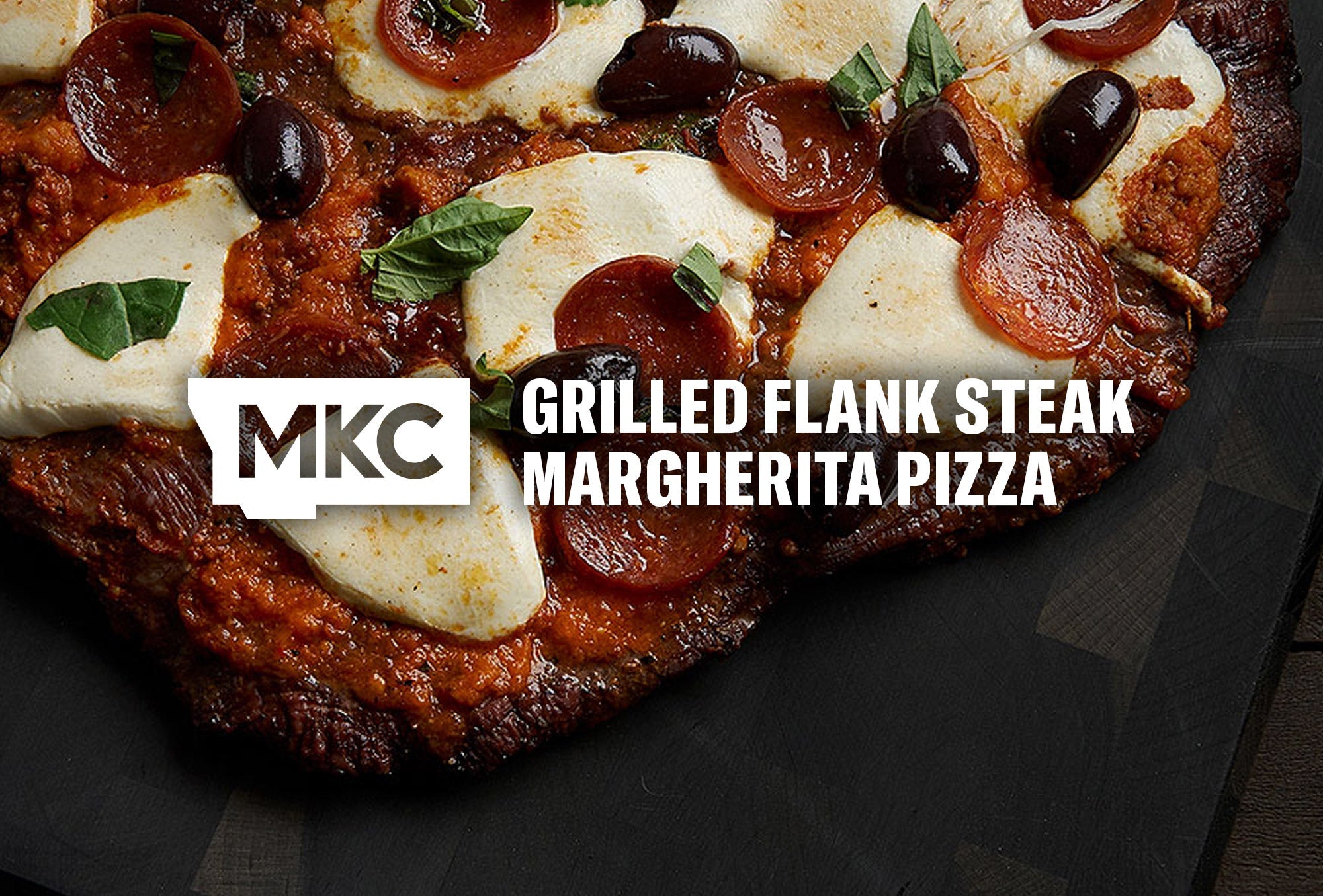 Grilled flank steak with pizza sauce, melted mozzarella, tomatoes, and basil, making the perfect Margherita pizza.
