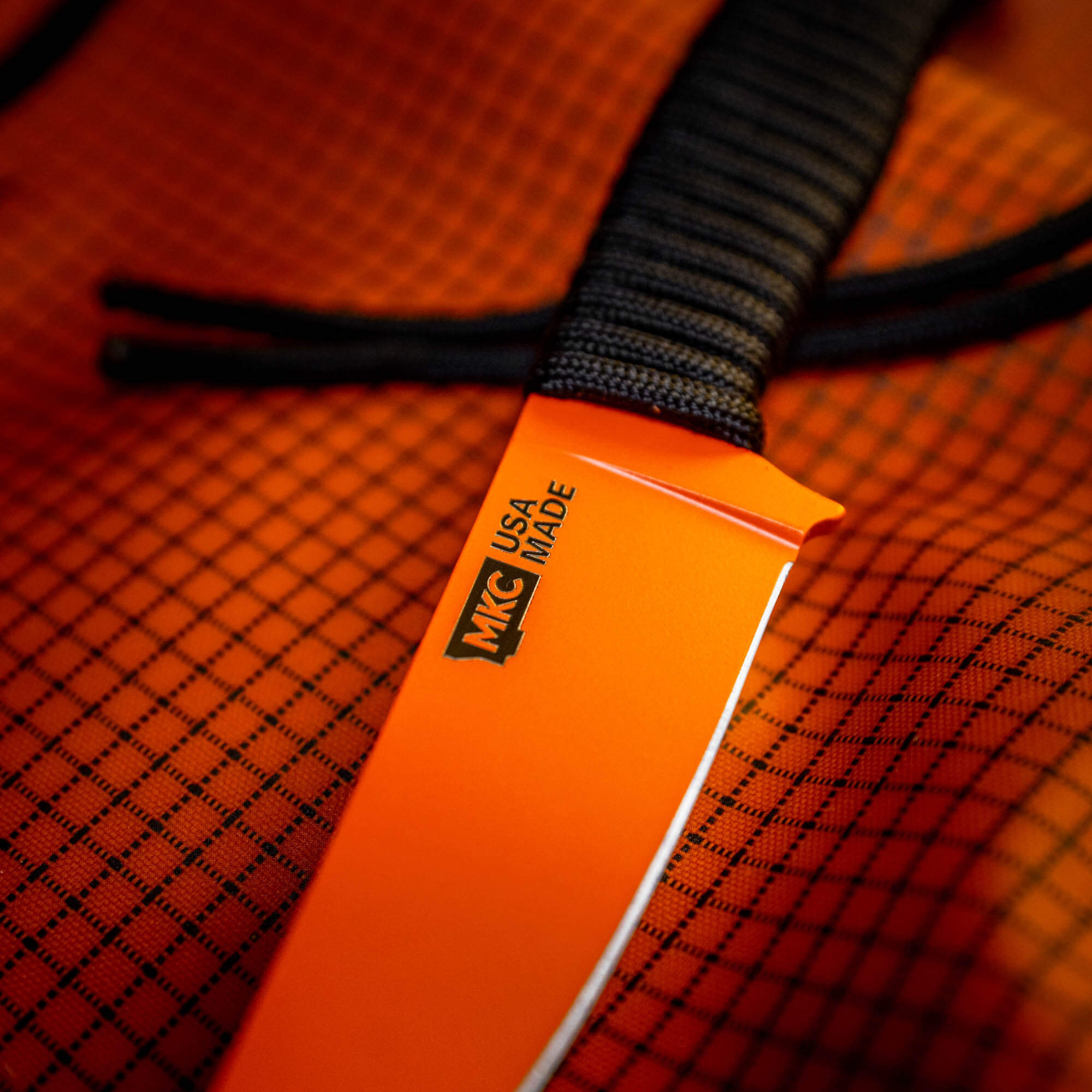 SPEEDGOAT 2.0 knife with Blaze Orange Cerakote finish, showcasing the MKC logo and textured handle. Ideal for outdoor use.