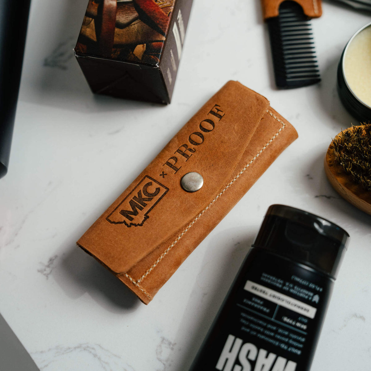 MKC X PROOF EDC Razor 2.0 in a leather case, showcasing a rugged design for everyday carry and outdoor use.