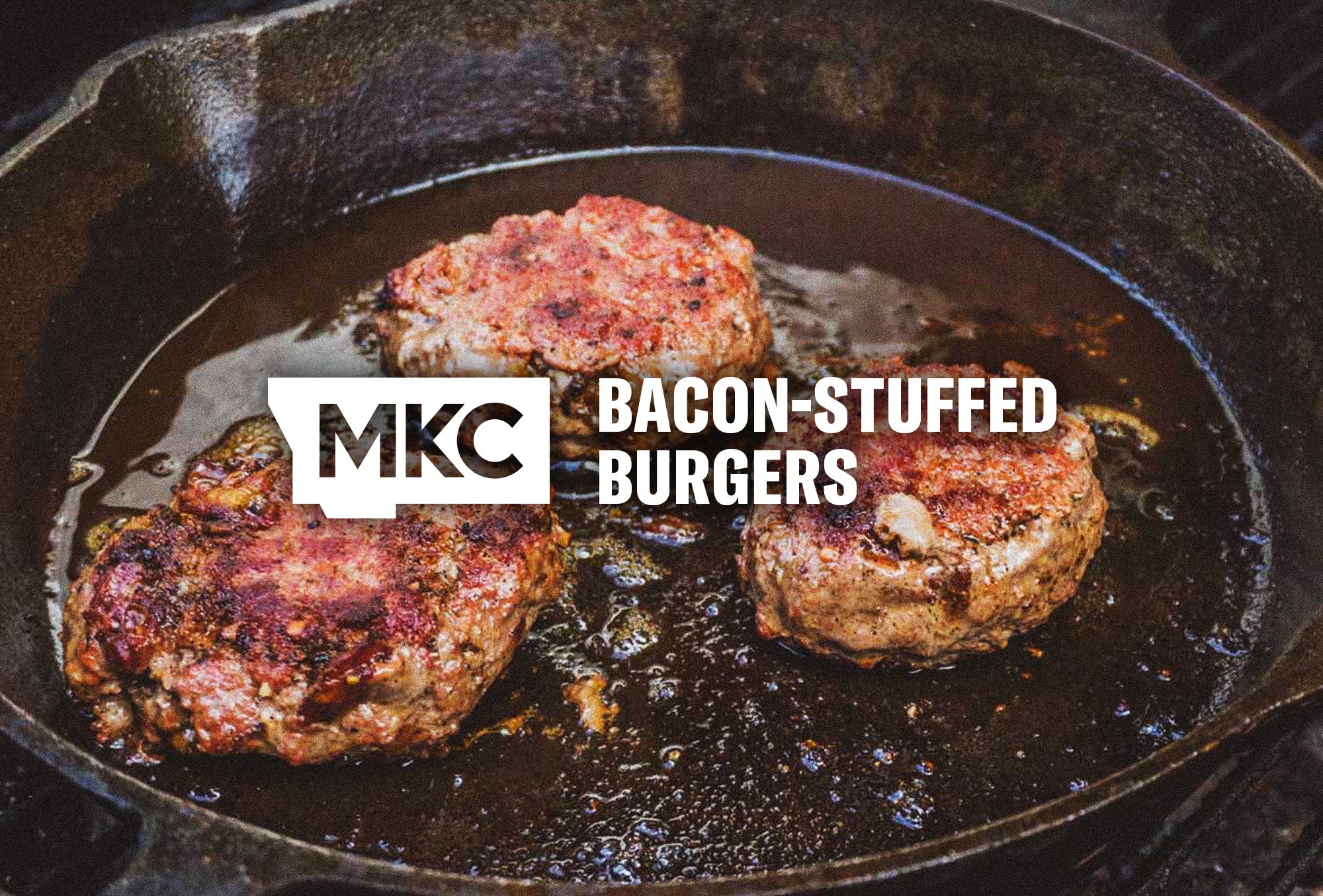 Three bacon‑stuffed burgers sizzling in a cast iron skillet, seared in bacon grease for a smoky, crispy finish.
