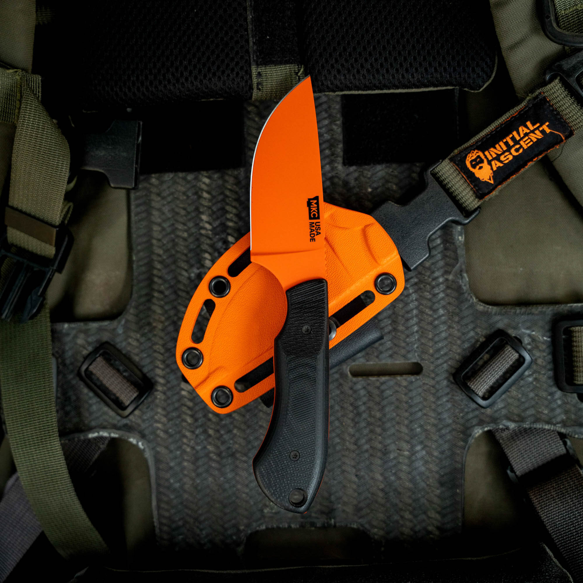 MKC Elk Knife with Blaze Orange Cerakote finish, featuring a durable handle and sheath, designed for outdoor enthusiasts.