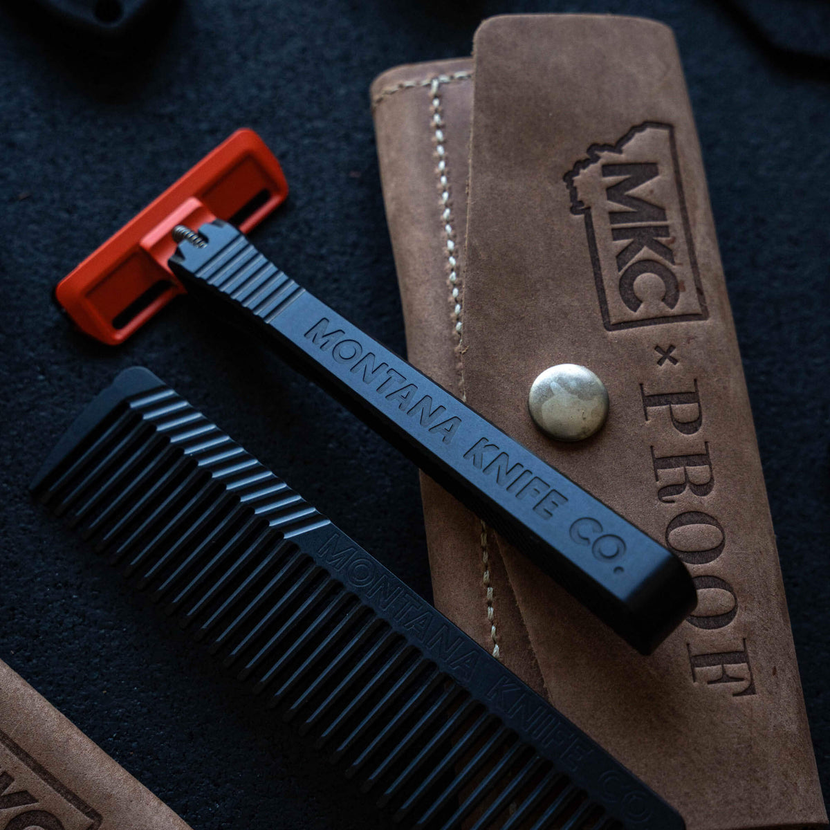 MKC X PROOF EDC Razor 2.0 with black handle, red blade, and leather sheath, designed for everyday carry and grooming.